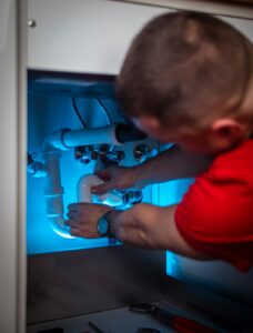 Professional plumber repairing under-cabinet plumbing in Oakville - how to choose the right plumber