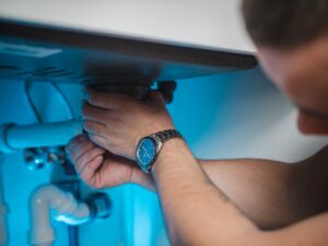 ProResults Plumbing plumber working under sink on pipes in Oakville home